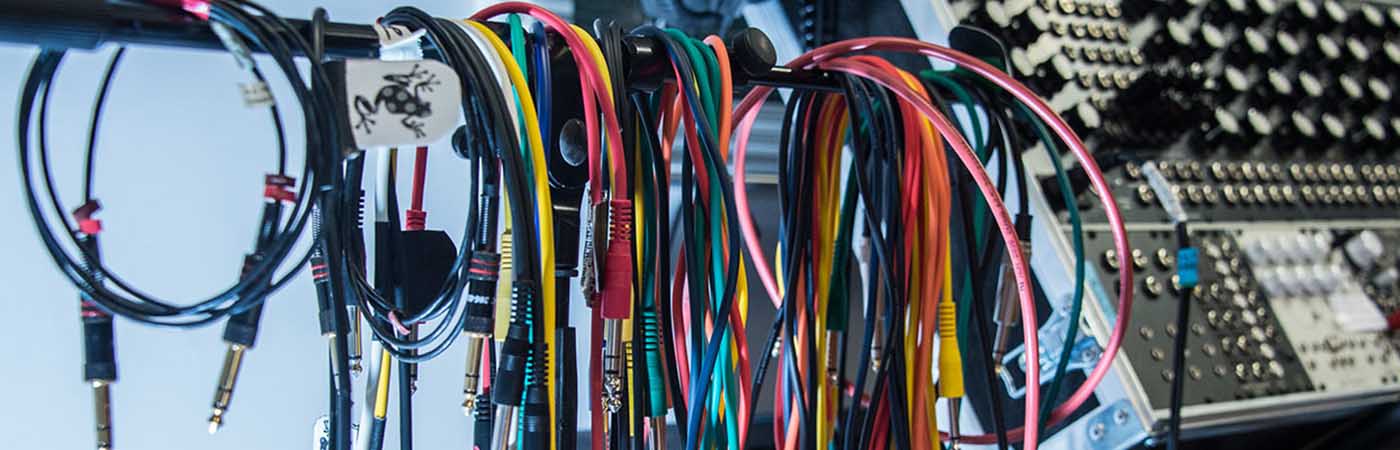 Close up of multi-coloured cables next to synth in studio 2