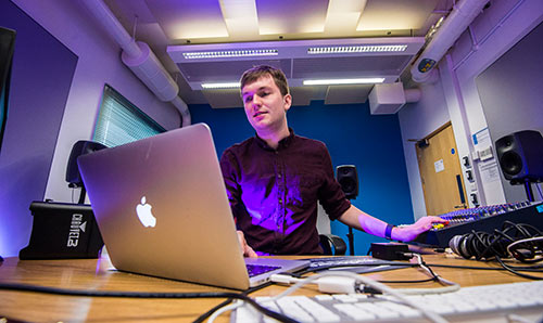 Male student with laptop in studio three